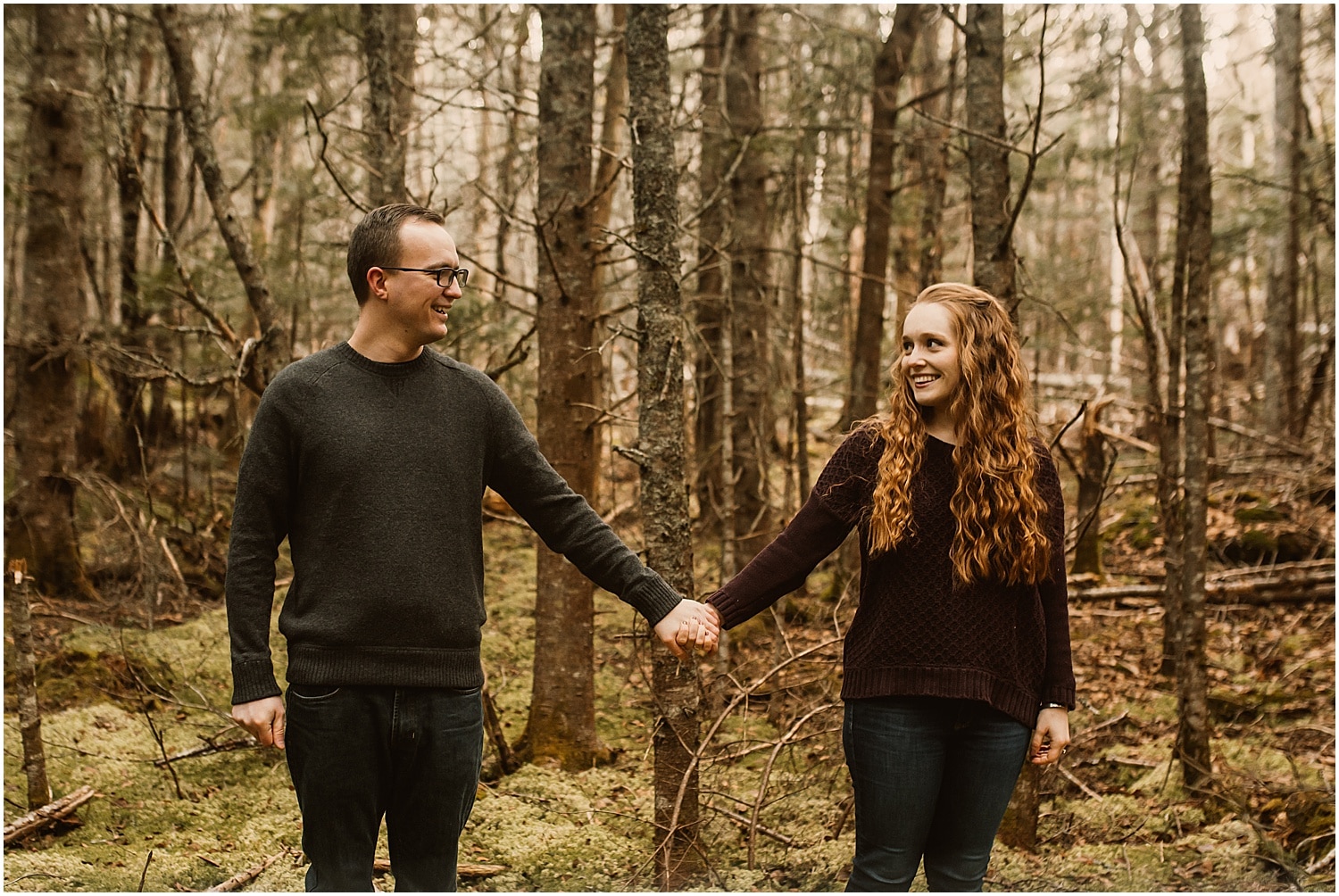 couple holding hands in eastern maine during their engagement photos