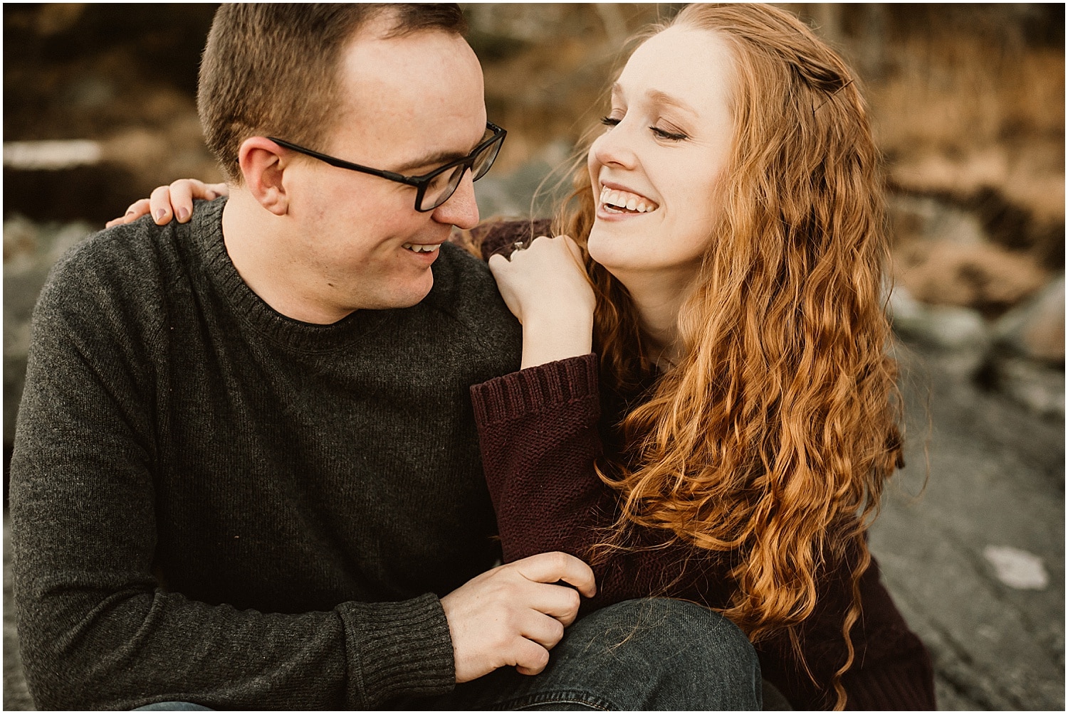 couple snuggling during their culter maine engagement photos