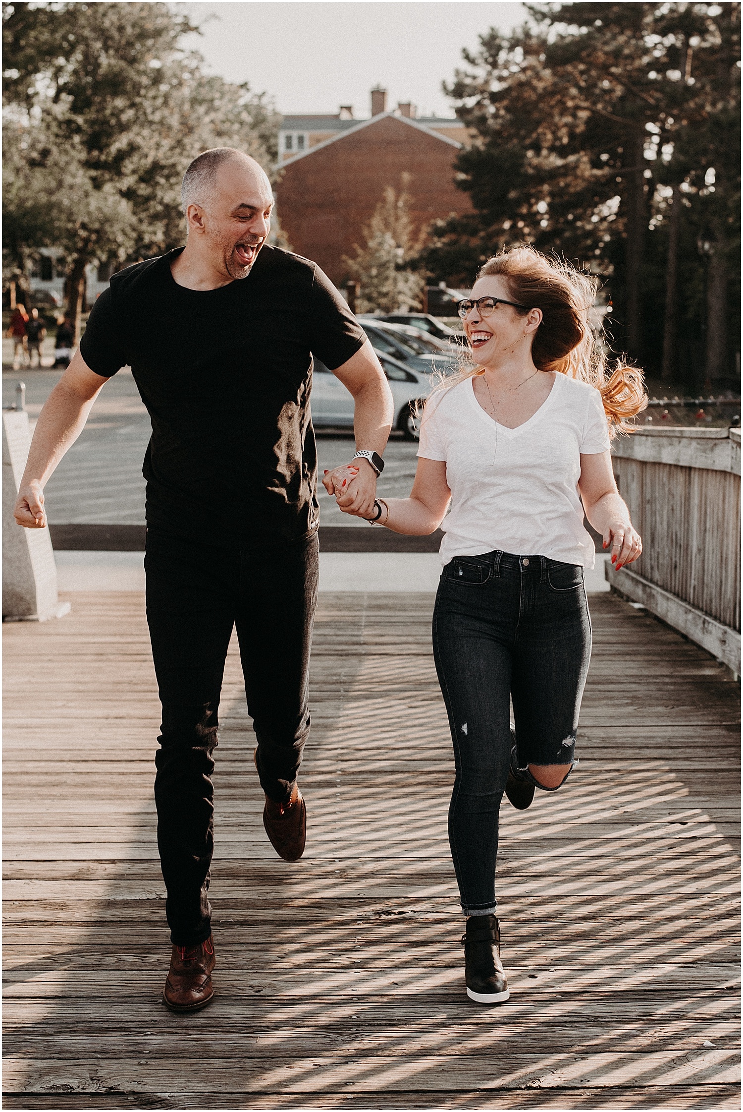 couple running and laughing together at their Portsmouth Engagement Photography