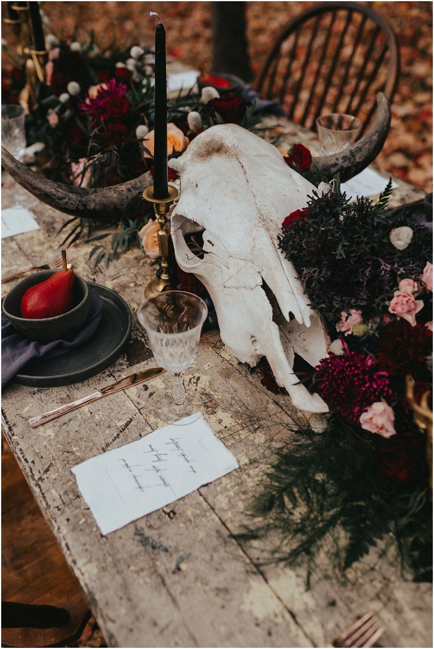 animal skull, black tableware and candles at this halloween wedding inspiration shoot