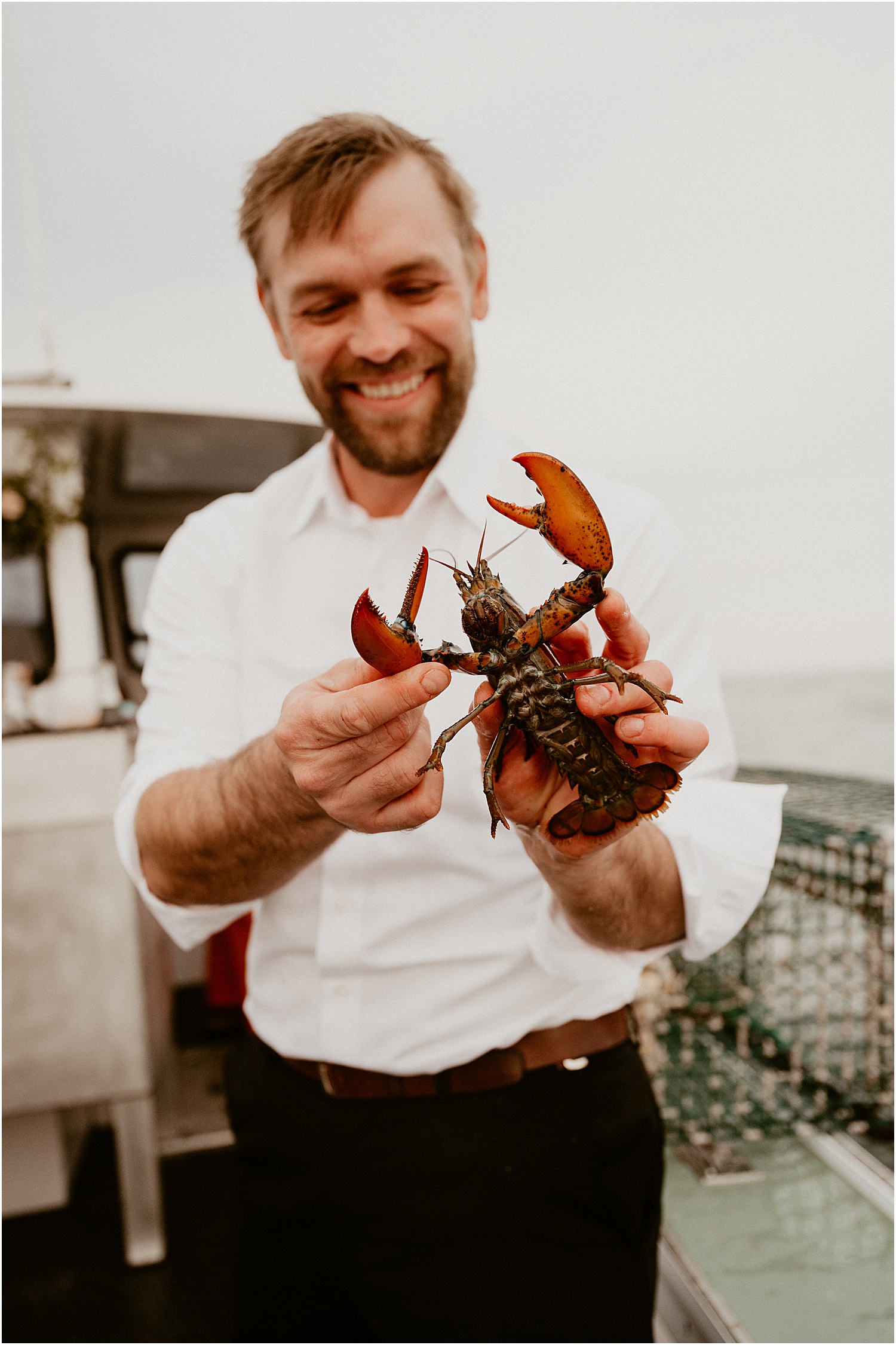 Man holds a lobster for Katelyn Mallett Photography